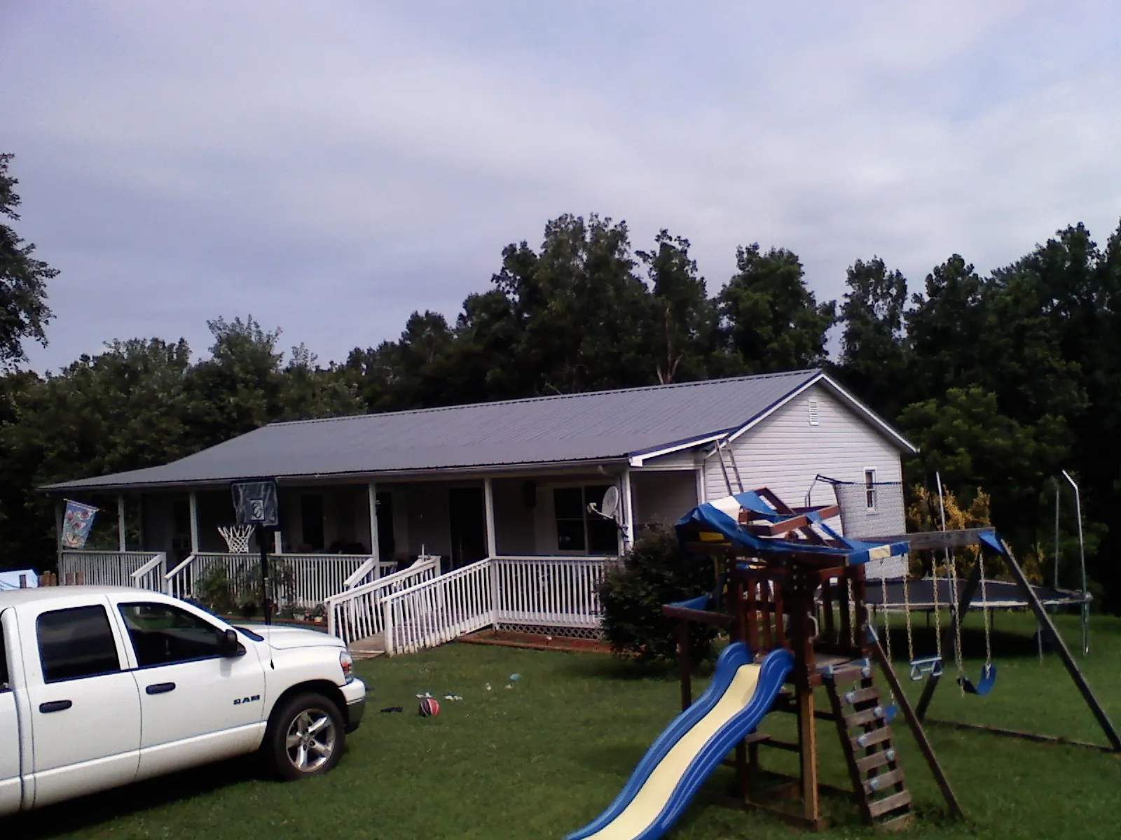 Dark metal roof on a country home with a full length front porch in Sugar Grove