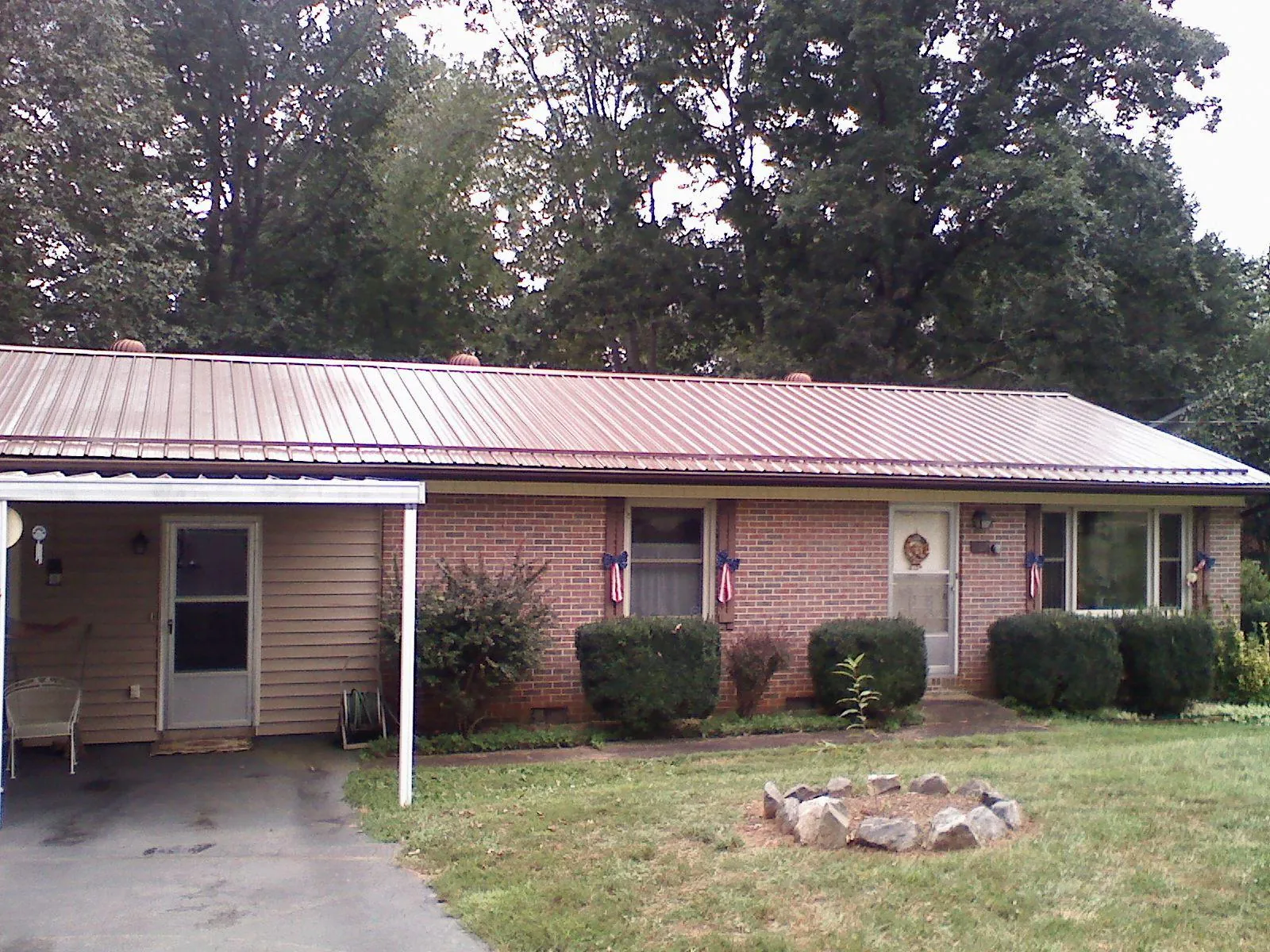 Bronze metal roof and carport on a brick ranch home — Roof Repair work by our crew in Sugar Grove